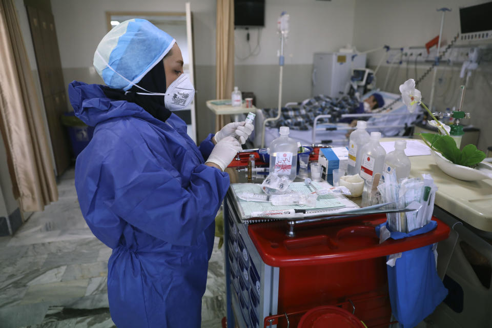 In this Tuesday, June 16, 2020, photo, a nurse prepares medicines for COVID-19 patients at the Shohadaye Tajrish Hospital in Tehran, Iran. After months of fighting the coronavirus, Iran only just saw its highest single-day spike in reported cases after Eid al-Fitr, the holiday that celebrates the end of Ramadan. (AP Photo/Vahid Salemi)