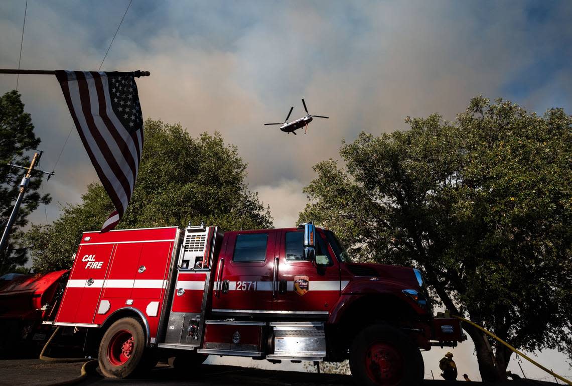 A Chinook helicopter works with Cal Fire personnel on the ground to control the Electra Fire in a gully between Clinton Bar Road and the North Fork Mokelumne River in Amador County on Wednesday.