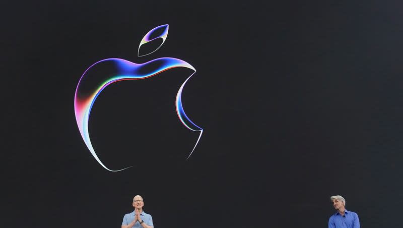 Apple CEO Tim Cook, left, joins Craig Federighi, senior vice president of software engineering, on stage during an announcement of new products on the Apple campus on June 5, 2023, in Cupertino, Calif. The Justice Department and 16 state and district attorneys general filed a suit against Apple accusing the smartphone giant of breaking federal antitrust law.