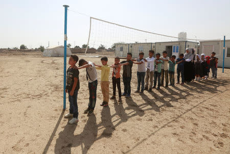 Children of Iraqi Kawliya group (known as Iraqi gypsies) play outside a school in al-Zuhoor village near the southern city of Diwaniya, Iraq April 16, 2018. Picture taken April 16, 2018. REUTERS/Alaa Al-Marjani