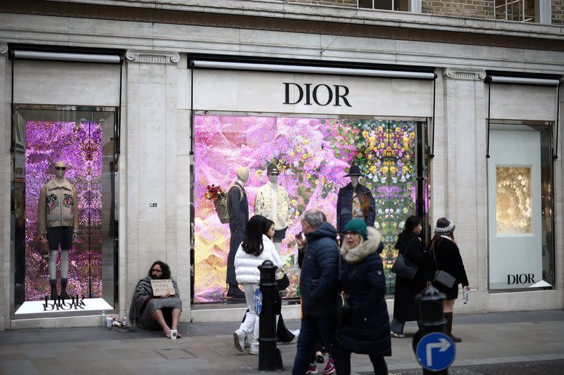People walk outside a Dior store on New Bond Street in London