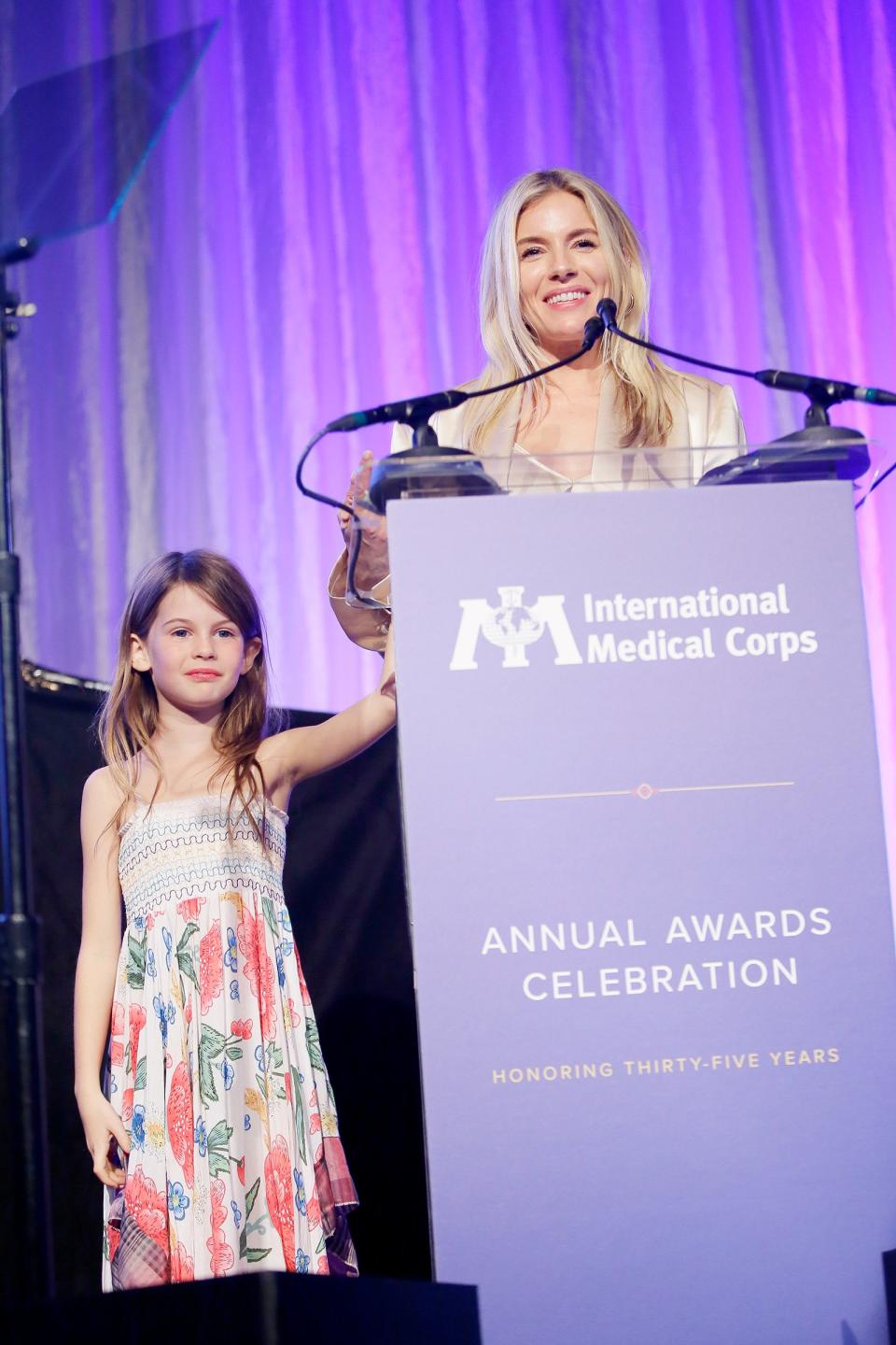 Sienna Miller shares the stage with daughter Marlowe Sturridge at the International Medical Corps Annual Awards Celebration on Thursday at the Beverly Wilshire Hotel in Beverly Hills.