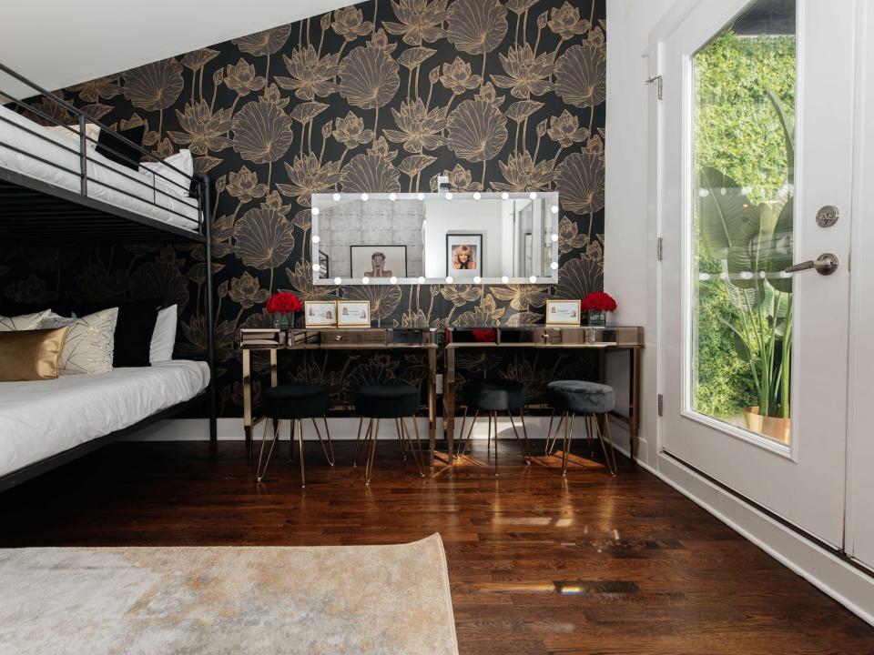 A bedroom with a a vanity and dark wallpaper.