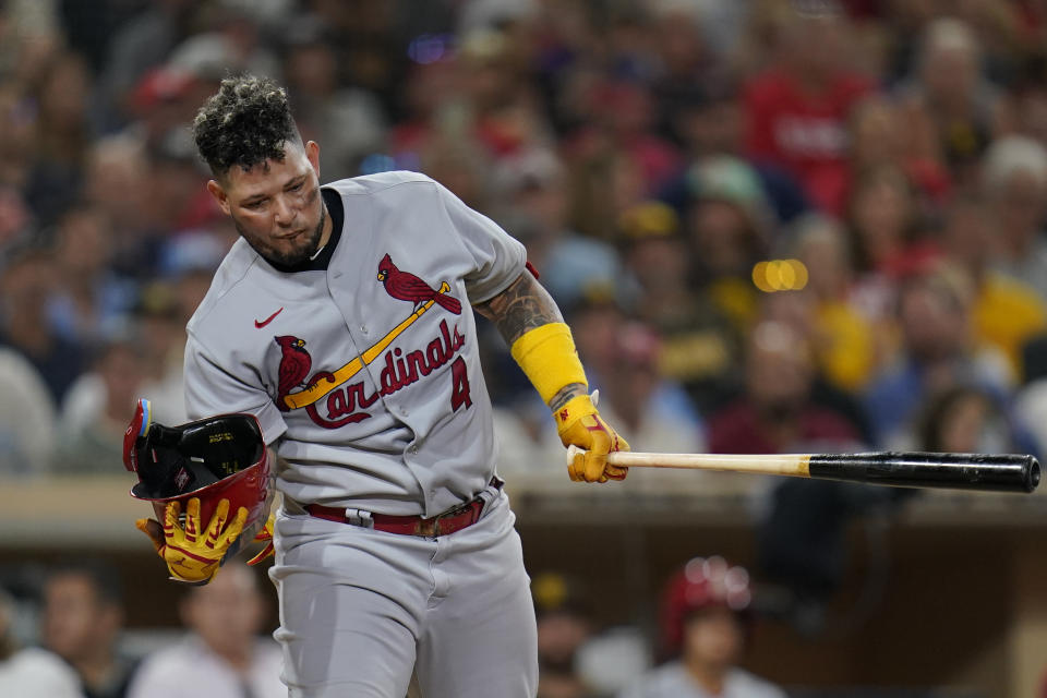 St. Louis Cardinals' Yadier Molina catches his helmet after it fell off during his fifth-inning at-bat in the team's baseball game against the San Diego Padres, Tuesday, Sept. 20, 2022, in San Diego. (AP Photo/Gregory Bull)