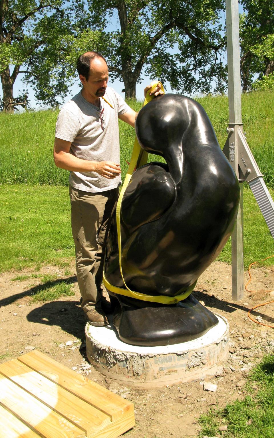 Sculptor Todd McGrain, artist-in-residence in the Lab of Ornithology at Cornell University, prepares to move his bronze sculpture of a Labrador duck in May 2009 when it was permanently installed in Elmira’s Brand Park.