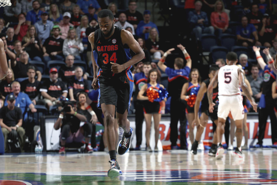 In this Jan. 18, 2020, photo provided by the University of Florida Athletic Association, Florida's Chris Sutherland (34) plays against Auburn during an NCAA college basketball game in Gainesville, Fla. Sutherland waited nearly five years to finally play college basketball. He worked his way onto Florida’s bench in January after serving as an arena worker, a practice player for the women’s team and a team manager for the men’s program. Gaining NCAA eligibility was a daunting task that required him to repay a $5,000 scholarship and remove his name and likeness off a website he created last year to sell streetwear he designed. (Courtney Culbreath/UAA Communications via AP)