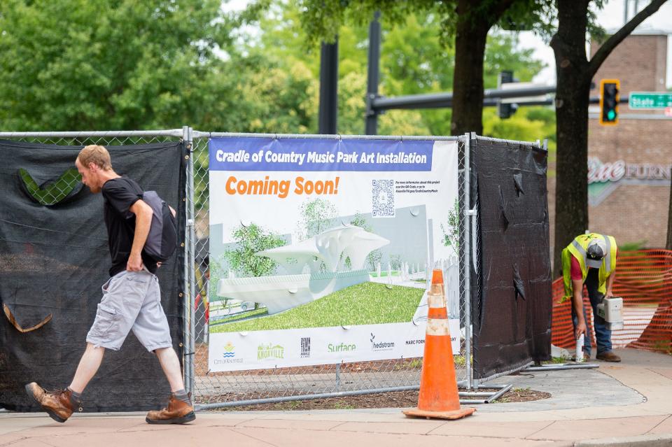 A rendering of Pier 865, an art piece being installed at Cradle of Country Music Park in downtown Knoxville, hangs from a fence to separate pedestrians from construction workers building the base.