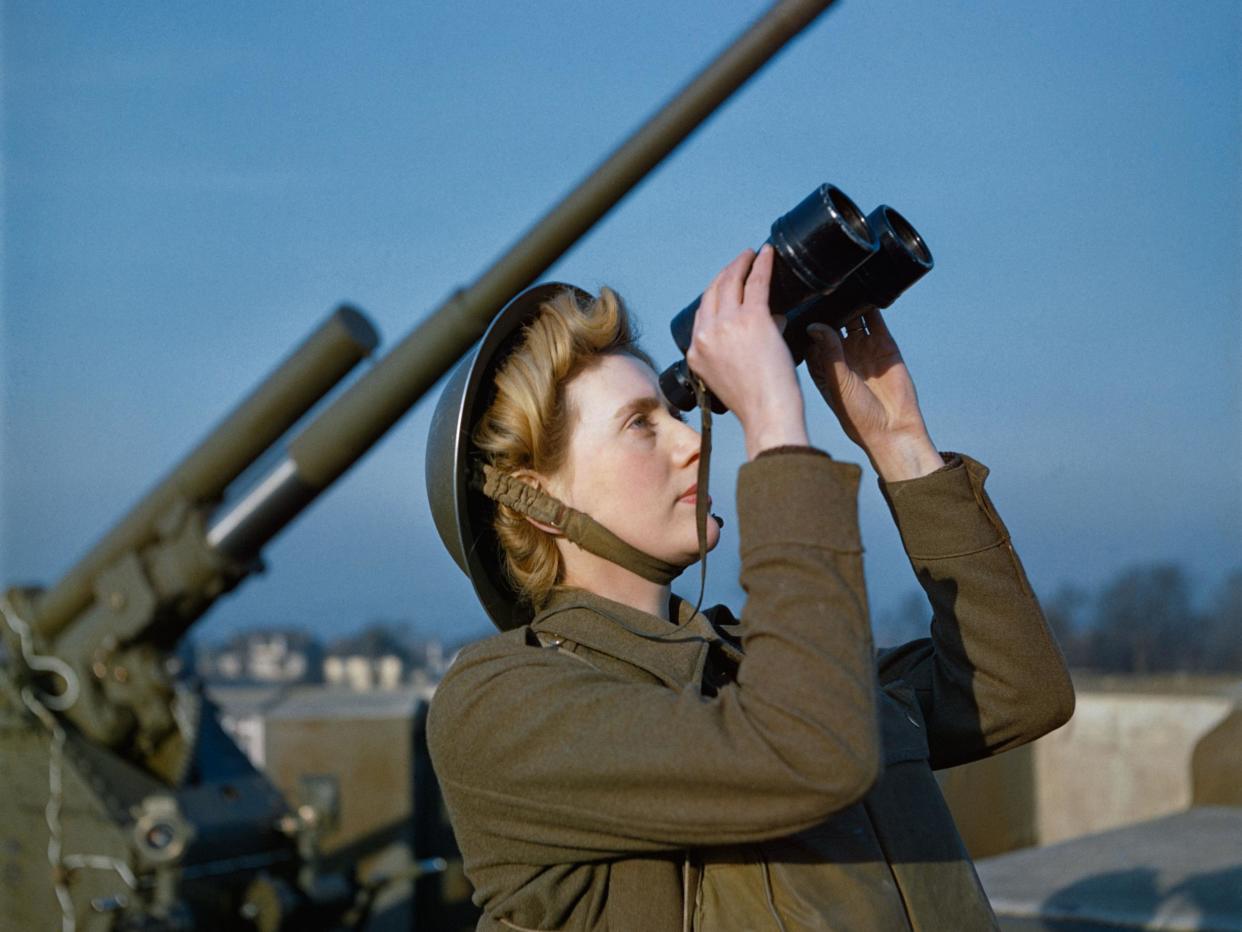 An Auxiliary Territorial Service (ATS) 'spotter' at a 3.7-inch anti-aircraft gun site, December 1942. The photo - taken on colour film - is one of a rare collection which has been released by the Imperial War Museum: Imperial War Museum