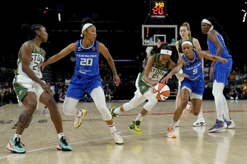 Connecticut Sun guard Jasmine Thomas (5) knocks the ball away from Seattle Storm guard Jordin Canada (21) during the first half of the Commissioner's Cup WNBA basketball game, Thursday, Aug. 12, 2021, in Phoenix. (AP Photo/Matt York)