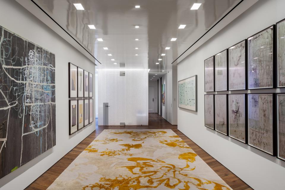 The spacious gallery is home to many pieces of the couple’s art collection (and is also where overflow guests are seated when the couple entertains large groups). They found the abstract patterned rug at Rug Art.