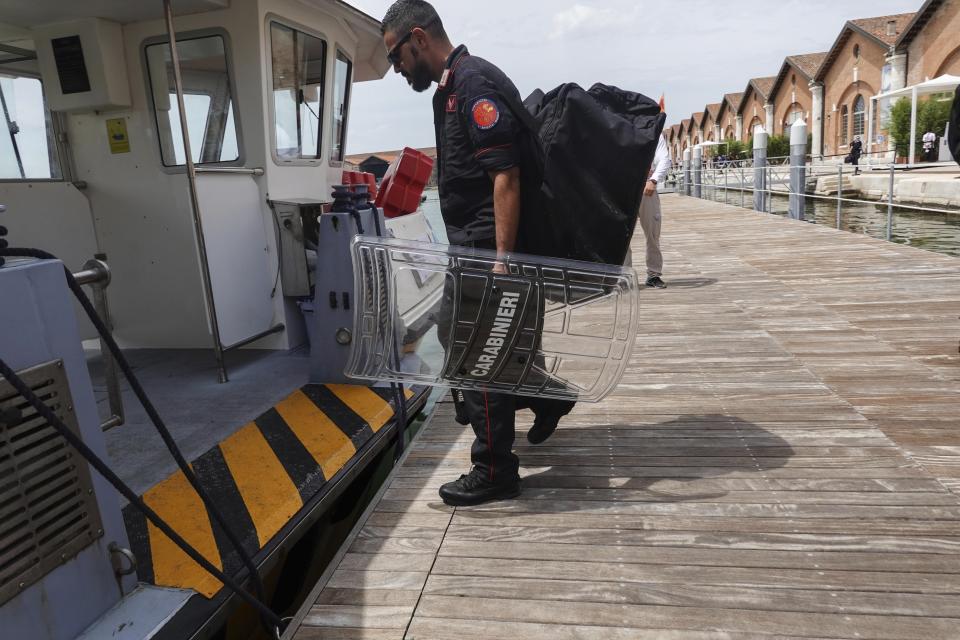 A Carabiniere embarks on a boat at the Arsenale, during a G20 meeting of Economy and Finance ministers and Central bank governors in Venice, Italy, Thursday, July 8, 2021. (AP Photo/Luca Bruno)