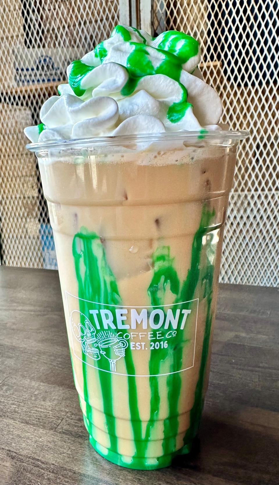 Shamrock Mmoonshine from Tremont Coffee Co., pictured served cold with nitro cold brew coffee, white chocolate peppermint infused with white or dark chocolate and decorated with a green white chocolate drizzle.