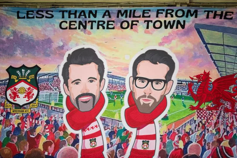 A banner of Wrexham owners Rob McElhenney and Ryan Reynolds during the Sky Bet League Two match between Wrexham and Doncaster Rovers at Racecourse Ground on September 9, 2023 in Wrexham, Wales.