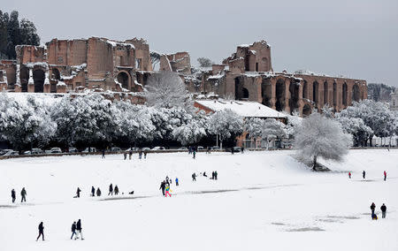 People walk during heavy snowfall at the Circus Maximus in Rome. REUTERS/Yara Nardi