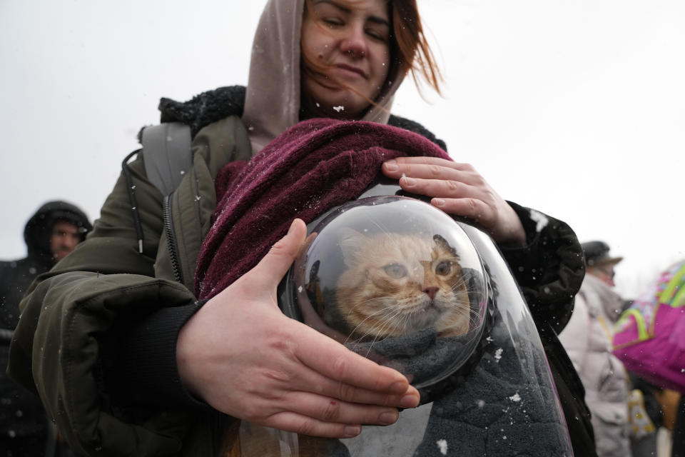 Nina, 26, holds a pet carrier with her cat (Sergei Grits / AP)