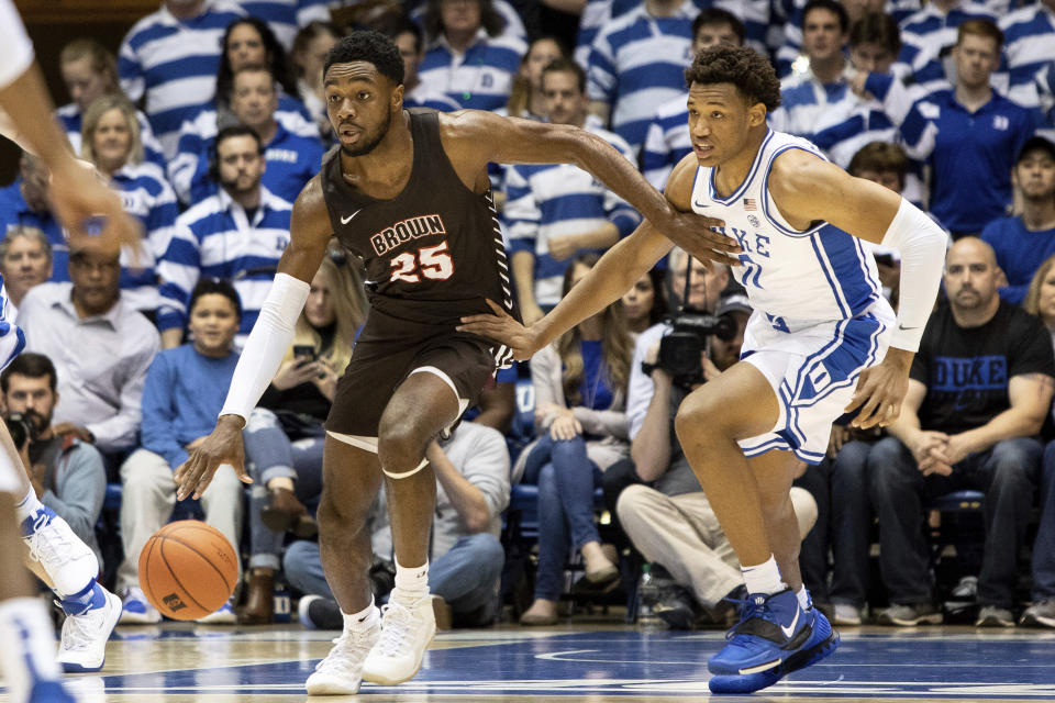 Brown's Tamenang Choh, left, dribbles the ball past Duke's Wendell Moore Jr., right, during the first half of an NCAA college basketball game in Durham, N.C., Saturday, Dec. 28, 2019. (AP Photo/Ben McKeown)