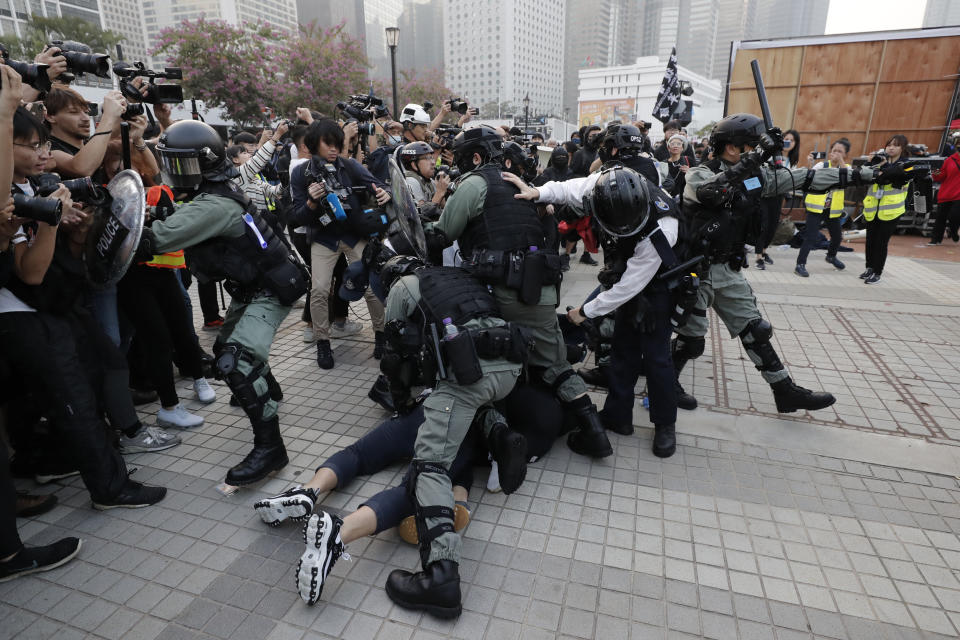 Riot policemen arrest protesters during a rally to show support for Uighurs and their fight for human rights in Hong Kong, Sunday, Dec. 22, 2019. Thousands of demonstrators attended a rally to protest against China's policy about Uighur minority. (AP Photo/Lee Jin-man)