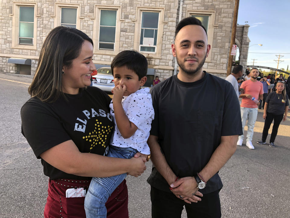 Tania Arzola, 26, left, her son, Derek Flores, 4, and her friend, Martin Olivas, 30, right, stand in line with thousands of others on Friday, Aug. 16, 2019, to pay respects to Margie Reckard, 63, who was killed by a gunman who opened fire at a Walmart in El Paso, Tex., earlier this month. Thousand of strangers from El Paso and around the country came this weekend to honor Reckard. Her long-time companion, Antonio Basco, says he felt so alone planning her funeral, that he invited the world to join him in remembering his companion of 22 years. (AP Photo/Russell Contreras)