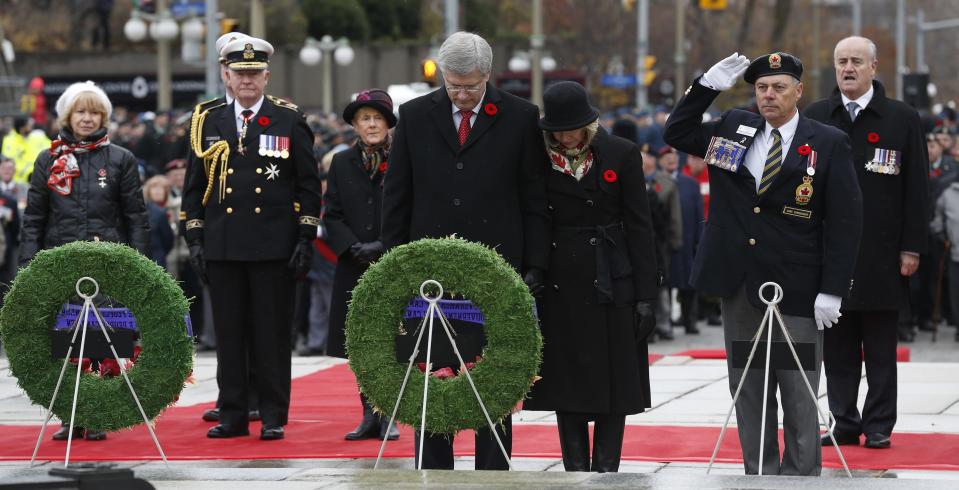 Canada's Prime Minister Harper and his wife Laureen bow their heads after laying a wreath during the Remembrance Day ceremony at the National War Memorial in Ottawa