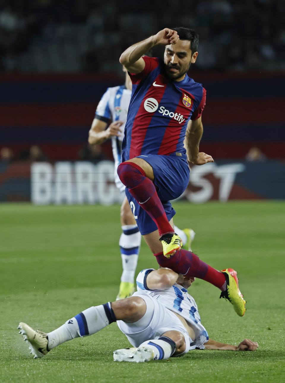 Barcelona's Ilkay Gundogan, top is tackled by Real Sociedad's Jon Pacheco during a Spanish La Liga soccer match between Barcelona and Real Sociedad at the Olimpic Lluis Companys stadium in Barcelona, Spain, Monday, May 13, 2024. (AP Photo/Joan Monfort)
