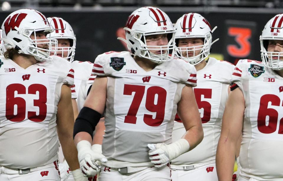 LAS VEGAS, NEVADA – DECEMBER 30: Offensive linemen Tanor Bortolini #63, Jack Nelson #79 and Cormac Sampson #62 of the Wisconsin Badgers walk to the line of scrimmage during the SRS Distribution Las Vegas Bowl against the Arizona State Sun Devils at Allegiant Stadium on December 30, 2021 in Las Vegas, Nevada. The Badgers defeated the Sun Devils 20-13. (Photo by Ethan Miller/Getty Images)
