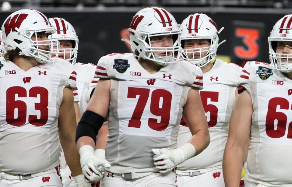 Offensive linemen Tanor Bortolini #63, Jack Nelson #79 and Cormac Sampson #62 of the Wisconsin Badgers walk to the line of scrimmage during the SRS Distribution Las Vegas Bowl against the Arizona State Sun Devils at Allegiant Stadium on Dec. 30, 2021 in Las Vegas, Nevada. The Badgers defeated the Sun Devils, 20-13. Ethan Miller/Getty Images