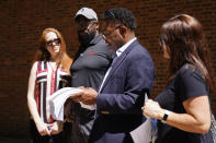 From left, Brooke Vaughn, her husband former NFL player Clarence Vaughn III, former NFL player Ken Jenkins and his wife Amy Lewis read a letter before delivering tens of thousands of petitions demanding equal treatment for everyone involved in the settlement of concussion claims against the NFL, to the federal courthouse in Philadelphia, Friday, May 14, 2021. (AP Photo/Matt Rourke)