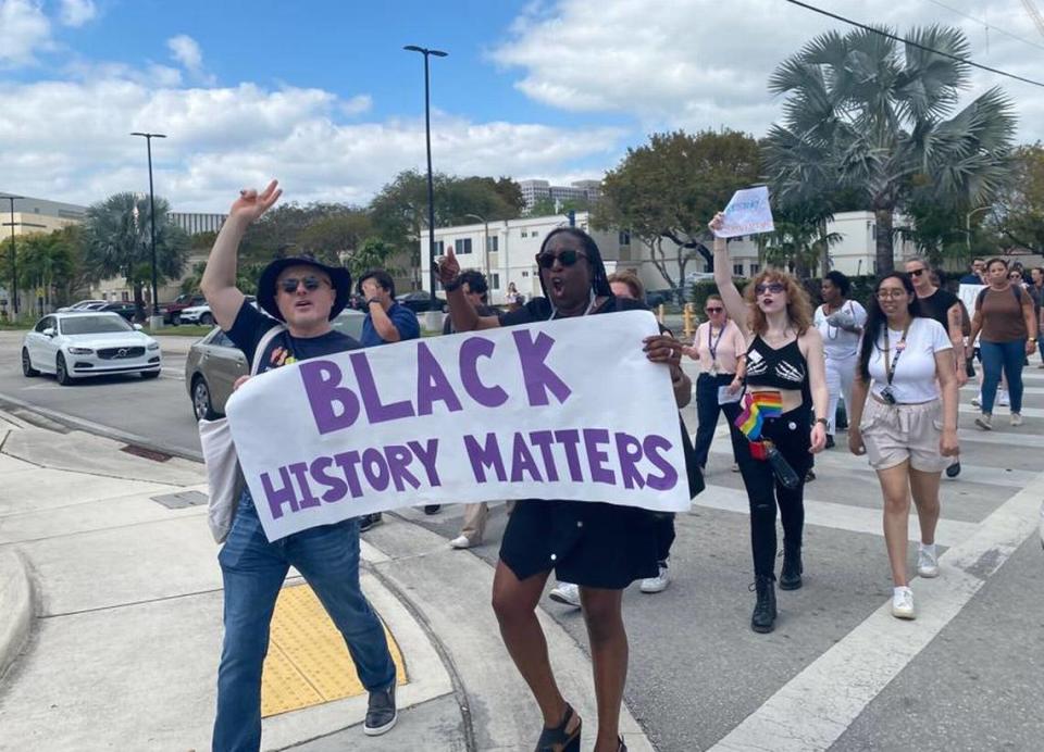 Carrying a sign reading “Black History Matters” professors from Florida International University Besiki Luka Kutateladze (left) and Melba Pearson joined dozens of students who walked out of class in protest of DeSantis’ proposal for higher education.