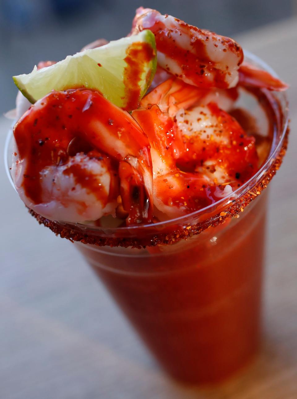 A Michelada Preparada topped with cucumber slices and shrimp and served with peanuts, salsa and tajin at Poquitos located in the former Go Bar on Prince Avenue.