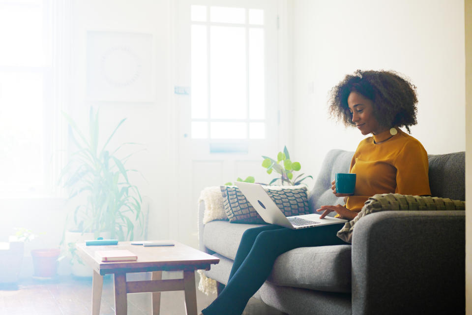 Woman sat on sofa with laptop