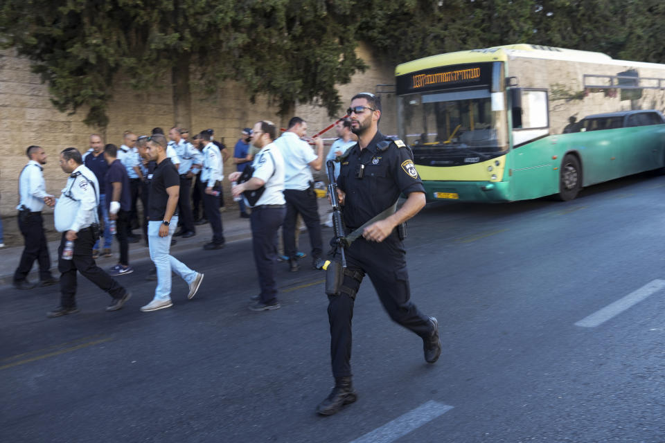 Israeli police officers work at the site of an attack in Jerusalem, Tuesday, July 19, 2022. Israeli emergency services responded to an attack on a bus in Jerusalem, the victim, a man in his 40s, was taken to hospital and sustained moderate wounds that were not life threatening. The attacker was shot by a nearby bystander and taken to hospital in critical condition. (AP Photo/Mahmoud Illean)