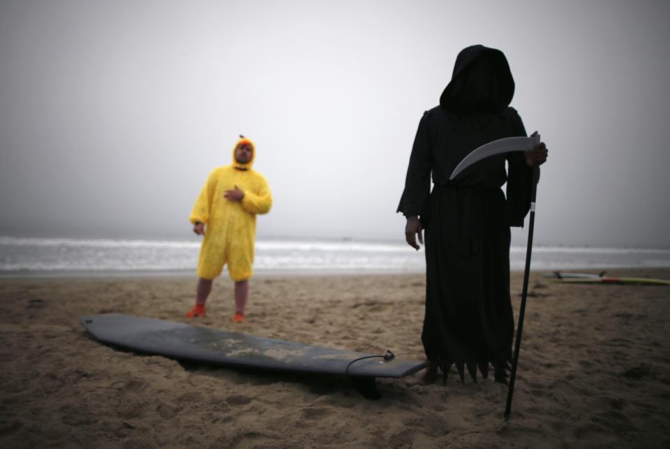 Owolo, dressed as the Grim Reaper, and Petrulis, dressed as a chicken, prepare to compete in the ZJ Boarding House Halloween Surf Contest in Santa Monica