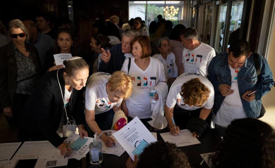 People from Beth Or temple wear matching tshirts that say “I am here with you” while signing in before PACT’s assembly on rising rents with local government officials at Barry University in Miami Shores.