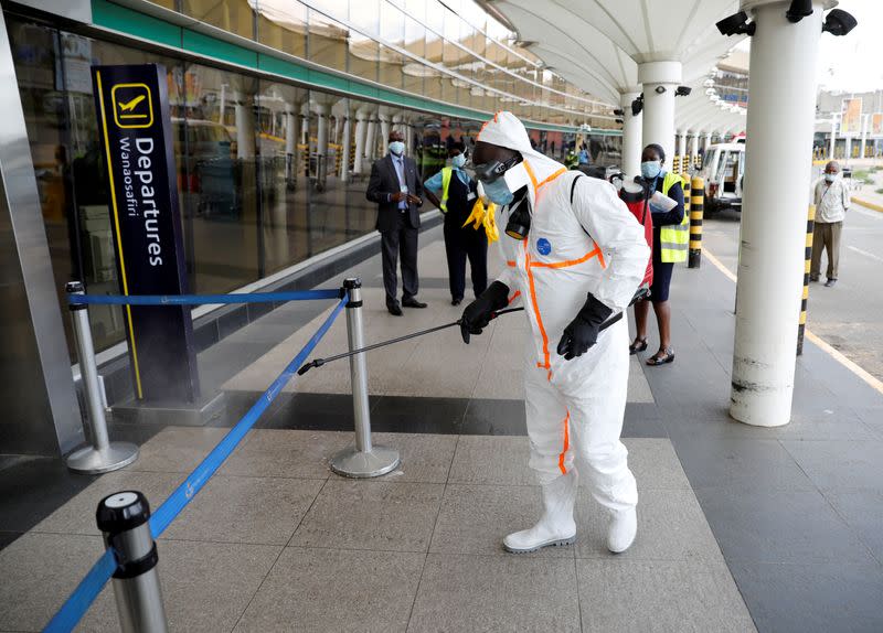 A health worker sprays disinfectant to prevent an outbreak of the coronavirus disease (COVID-19) at the Jomo Kenyatta International Airport in Nairobi