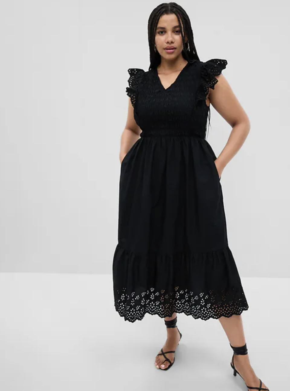 plus size black model wearing black sandals and Ruffle Sleeve Smocked Midi Dress in black (photo via Gap)