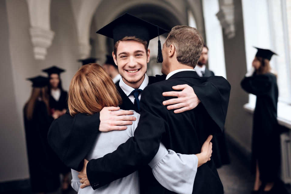 College graduate hugging his parents