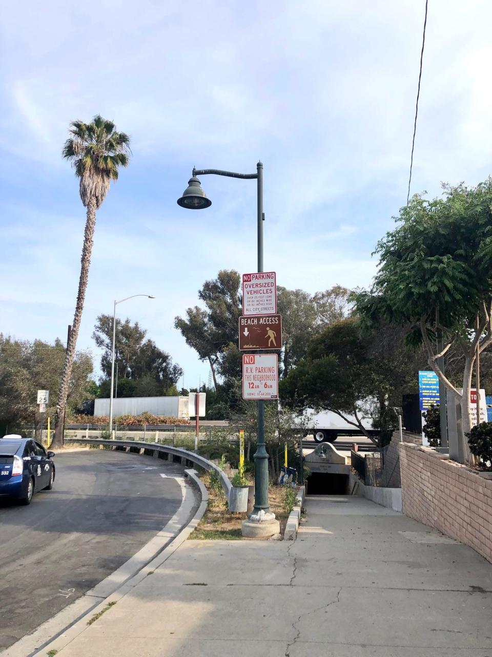 The sidewalk slopes downhill toward a tunnel to get to the beach in Montecito