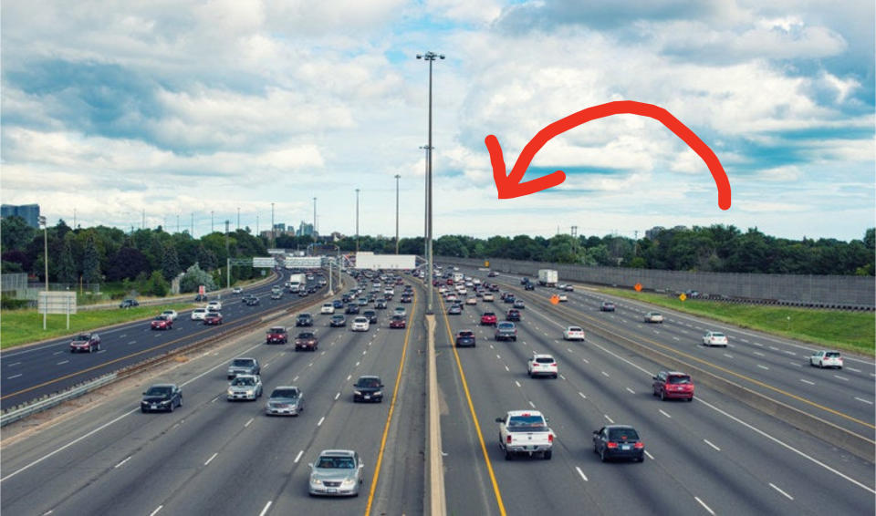 an arrow pointing to an busy interstate