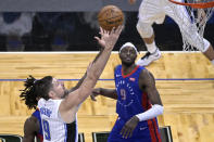 Orlando Magic center Nikola Vucevic (9) goes up for a shot in front of Detroit Pistons center Isaiah Stewart, obscured, and forward Jerami Grant (9) during the second half of an NBA basketball game, Tuesday, Feb. 23, 2021, in Orlando, Fla. (AP Photo/Phelan M. Ebenhack)