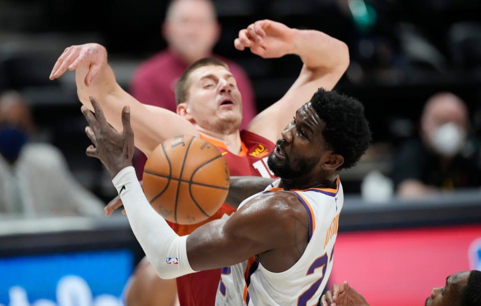 Phoenix Suns center Deandre Ayton, front, fights for control of a rebound with Denver Nuggets center Nikola Jokic in the first half of Game 4 of an NBA second-round playoff series Sunday, June 13, 2021, in Denver. (AP Photo/David Zalubowski).