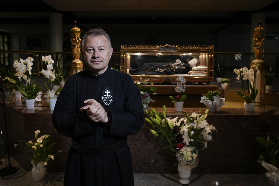 The Rev. Dario Di Giosia, the rector of the St. Gabriele dell'Addolorata sanctuary in Isola del Gran Sasso near Teramo in Central Italy, poses for a portrait in the crypt with the relics of the saint, Sunday, June 4, 2023. (AP Photo/Domenico Stinellis)