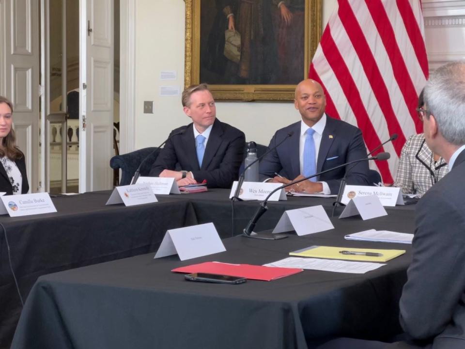 Democratic Gov. Wes Moore, right, speaks during a climate goals roundtable discussion at the State House on April 3, 2023. At left, Nathan Hultman, director of the Center for Global Sustainability at the University of Maryland, listens to the governor.