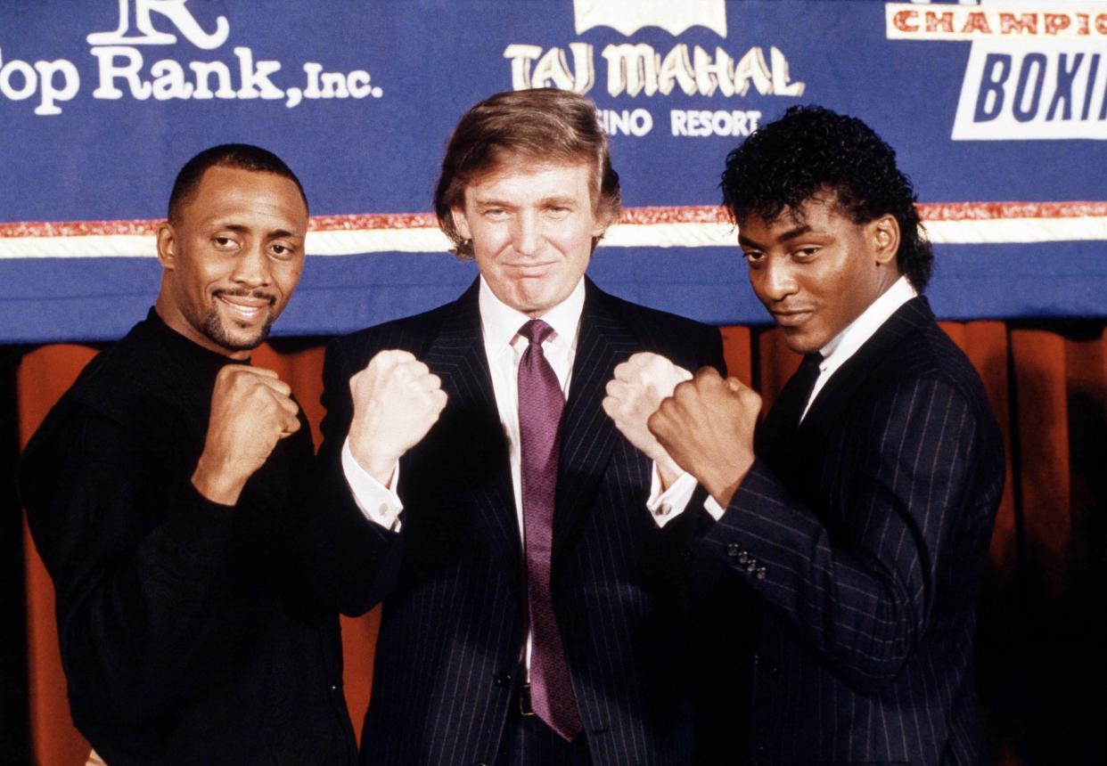 Developer Donald Trump, center, is flanked by super middleweight champion Thomas Hearns, left, of Detroit, and Michael Olajide of Canada at a news conference in New York on Thursday, Feb. 15, 1990.