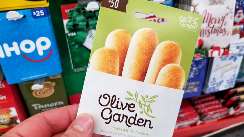 Person holding Olive Garden gift card