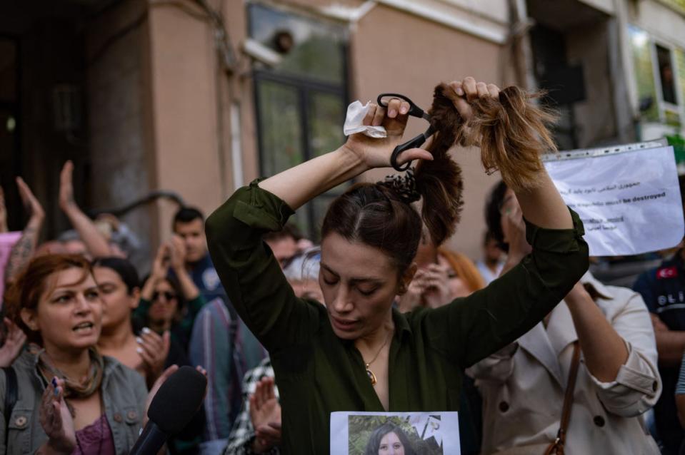 Nasibe Samsaei, an Iranian woman living in Turkey, cuts her ponytail off during a protest outside the Iranian consulate in Istanbul (AFP/Getty)