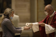 Father Jose Maria Galvan, wearing gloves to prevent the spread of COVID-19, places the host in the hands of a parishioner during the morning mass at St. Eugenio Church, in Rome, Monday, May 18, 2020. Italy partially lifted lockdown restrictions Monday after a two-month coronavirus lockdown. (AP Photo/Alessandra Tarantino)