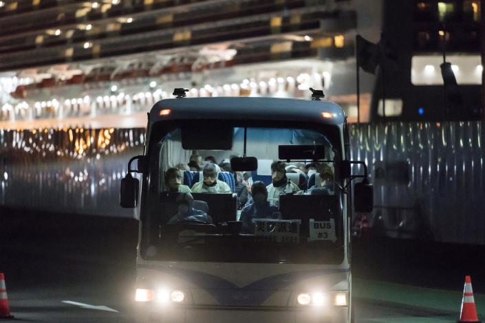 A bus carrying passengers, who will board the Qantas aircraft chartered by the Australian government, from the quarantined Diamond Princess cruise ship drive at the Daikoku Pier on February 19, 2020 in Yokohama, Japan.