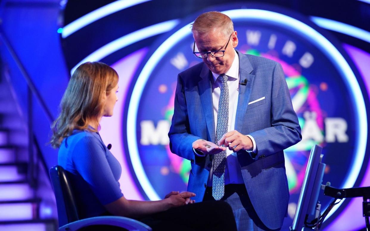 Weil Angela Merkel und Thomas Gottschalk einst der Kandidatin Anja Scharf das Trinkgeld verweigert hatten, half Günther Jauch aus mit dem, was er in seinen Hostentaschen fand. (Bild: RTL / Stefan Gregorowius)