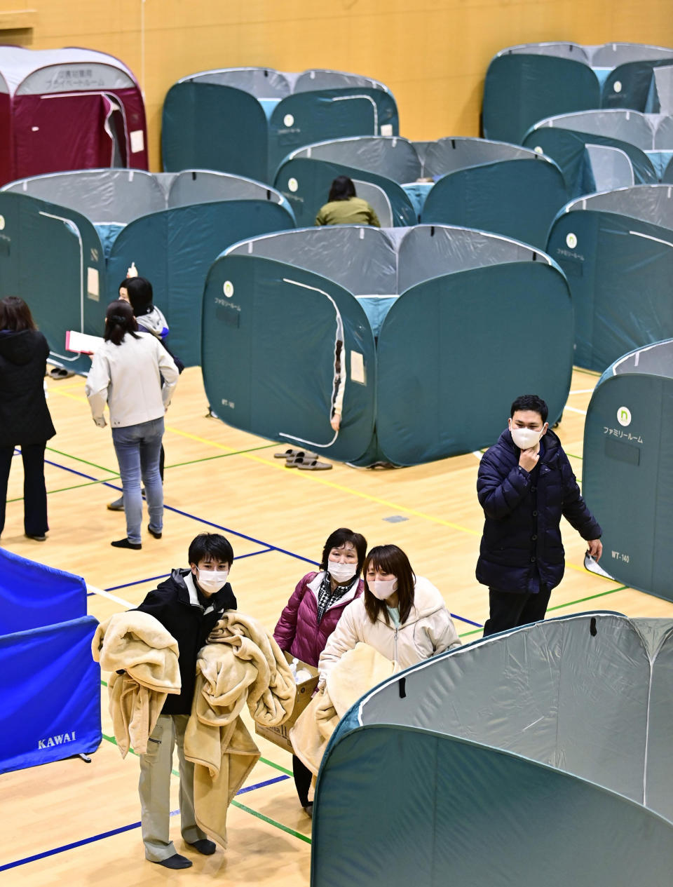 Evacuees shelter at a gym as an earthquake hit the area, in Soma, Fukushima prefecture, northeastern Japan, Sunday, Feb. 14, 2021. A strong earthquake hit off the coast of northeastern Japan late Saturday, shaking Fukushima, Miyagi and other areas, but there was no threat of a tsunami, officials said.(Kyodo News via AP)