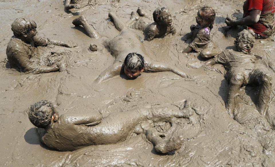 Children wallow in the mud during Mud Day at the Nankin Mills Park, Tuesday, July 9, 2019, in Westland, Mich. The annual day sponsored by the Wayne County Parks takes place in a 75' x 150' giant mud pit that gives children the opportunity to get down and dirty at one of the messiest playgrounds Southeast Michigan has ever seen. (AP Photo/Carlos Osorio)